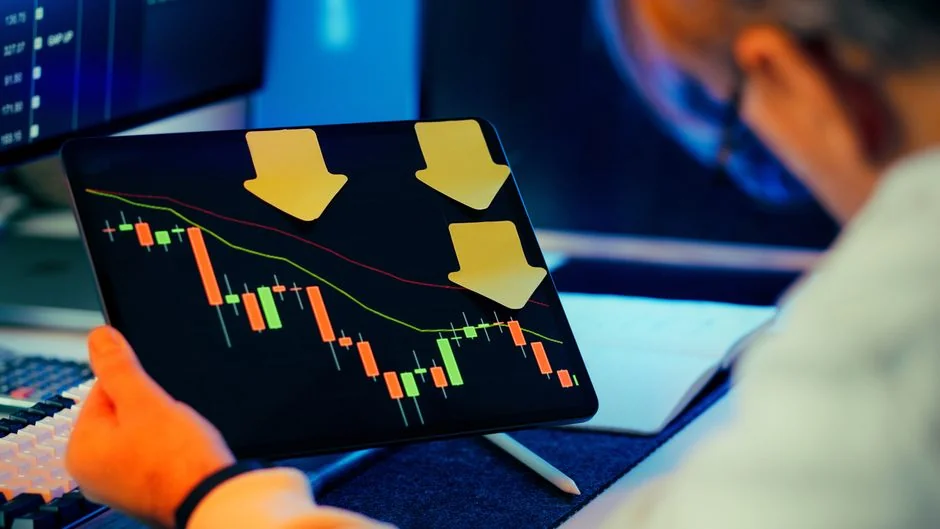 about-us Two businessmen analyze stock market data using a smartphone and laptop in a modern office setting.
